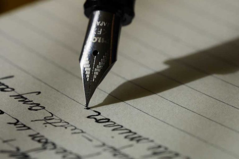 Ink pen on paper with writing in cursive script