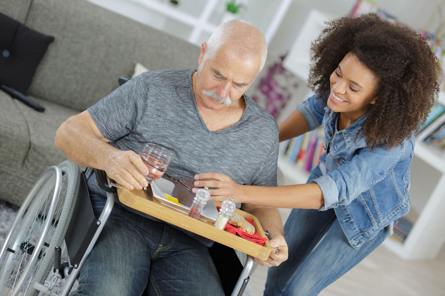 Young lady helping a gentleman in a wheelchair