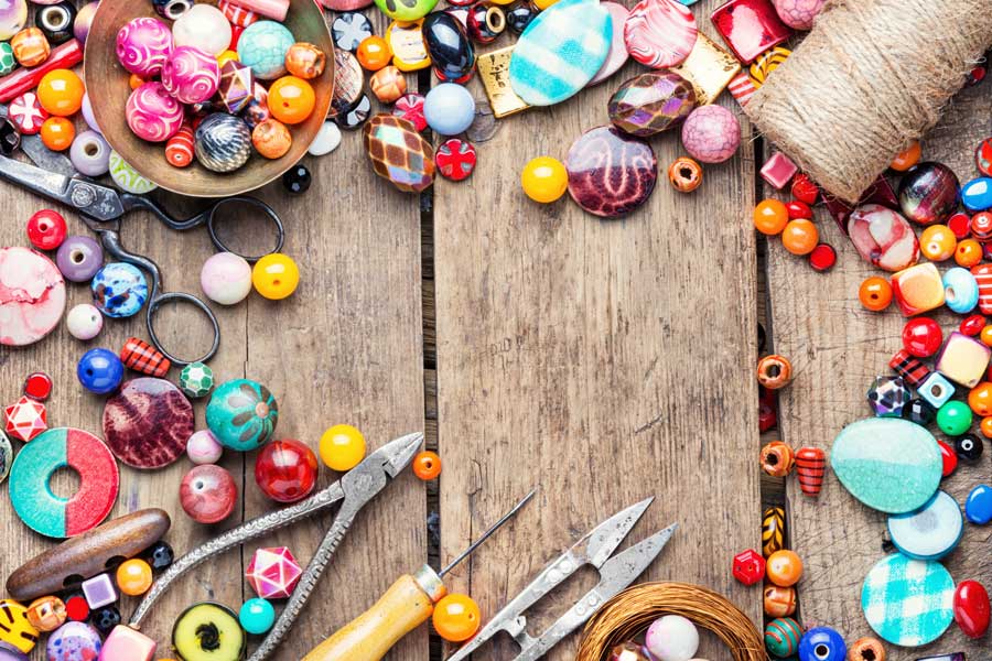 coloured crafting beads and other crafting items on a wooden table