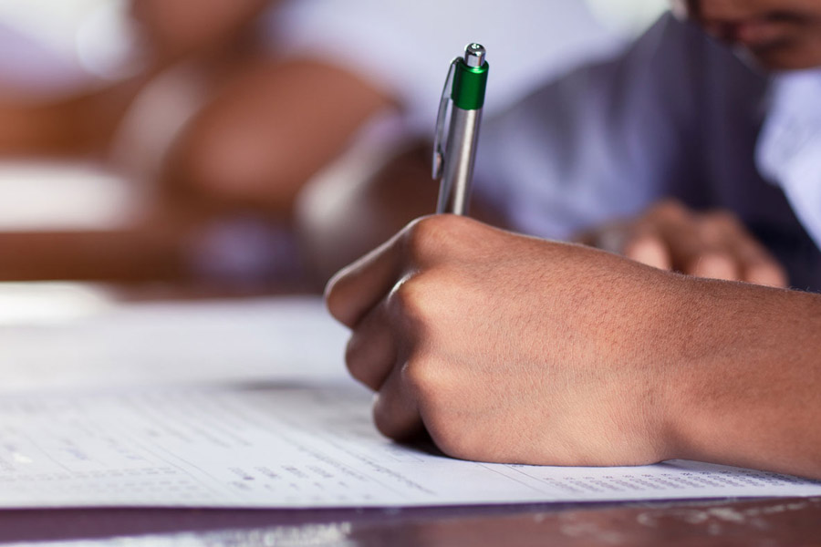close up of hand holding pen writing on a piece of paper