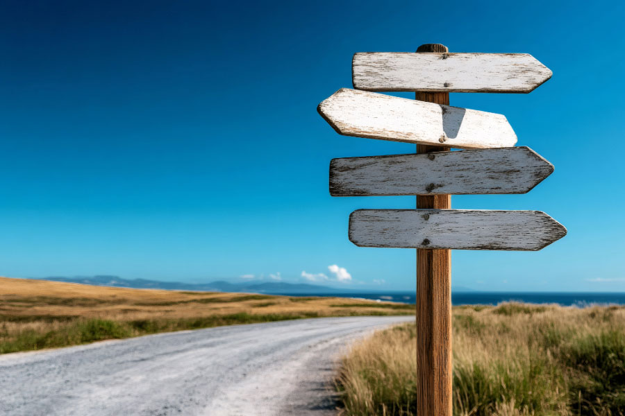 Image of signpost on road with mountains in the far distance