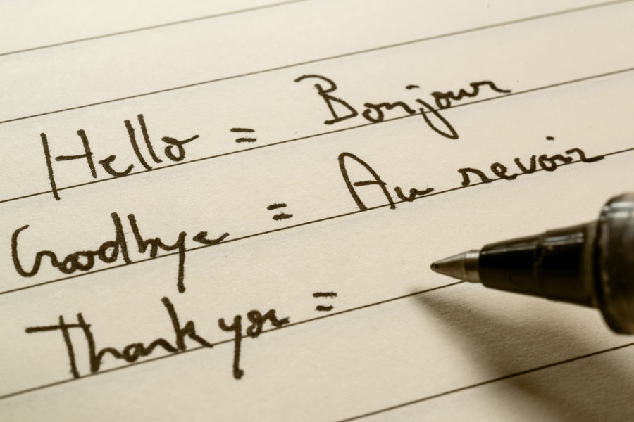 pen and paper with writing showing different language translations