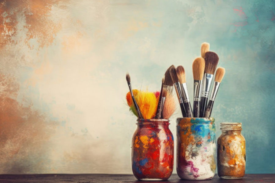 paint covered jars filled with paintbrushes